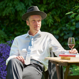 Der Autor Eberhard Michaely mit Hut und Wein